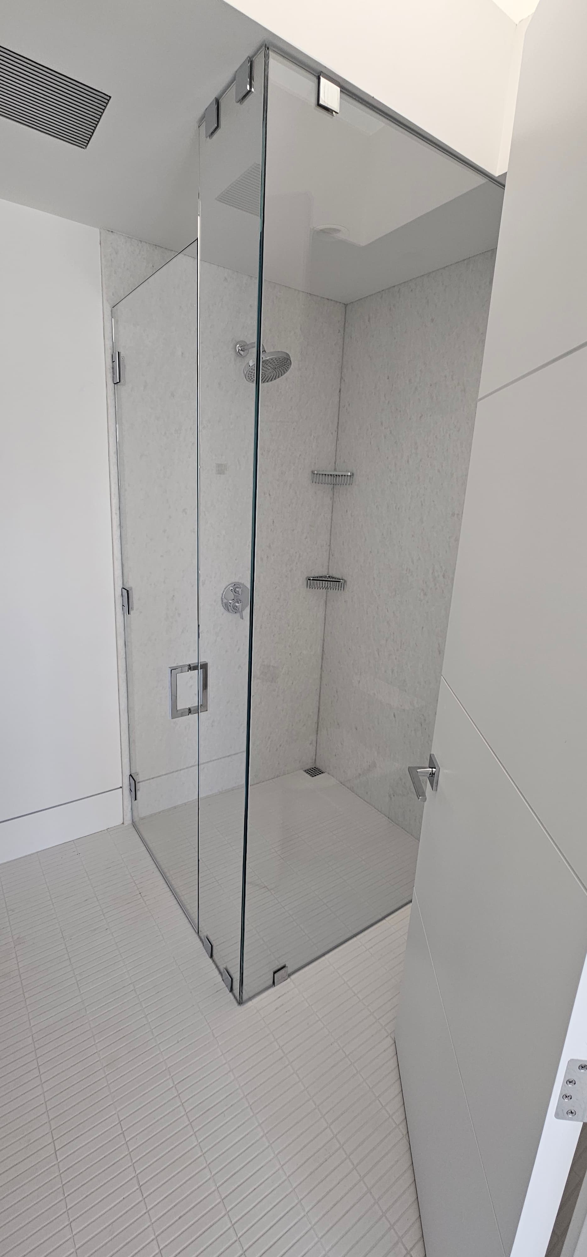 Frameless shower enclosure with marble walls