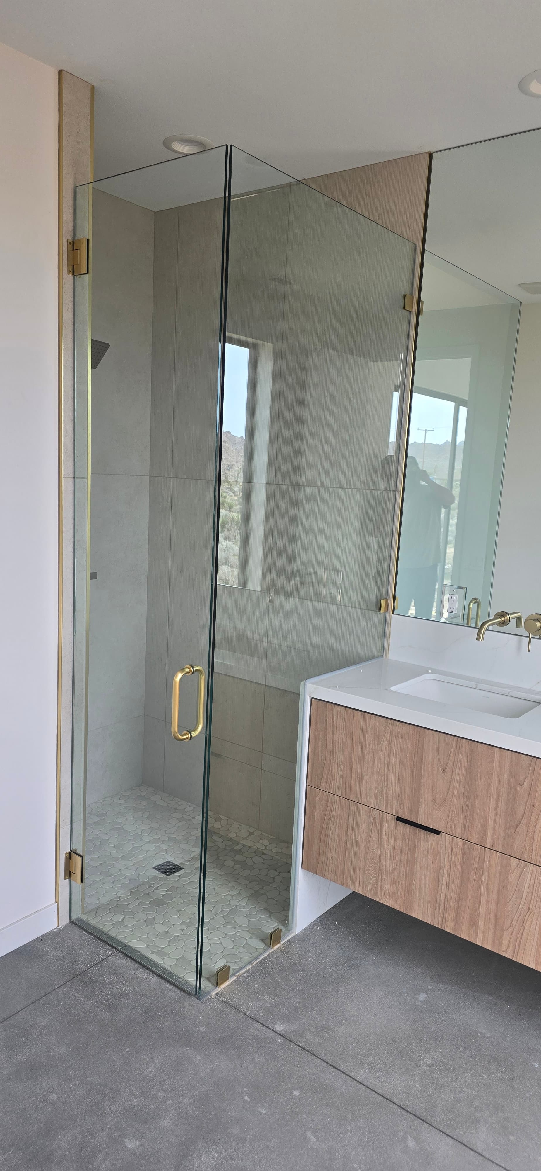 Frameless shower with brushed gold hardware